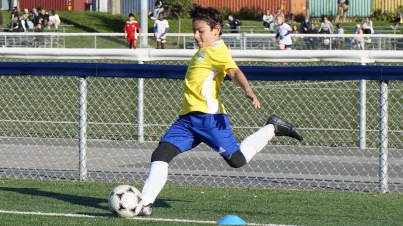 Nico as a child striking the ball in the ARSQ Québec region kit