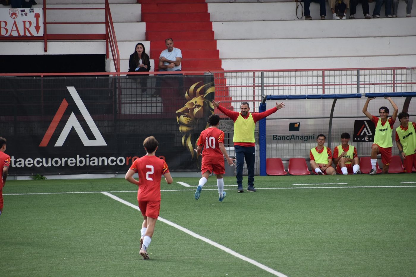 Nico celebrating his goal with the coach in front of the bench